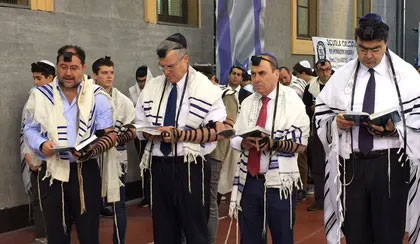 Group of Jewish men praying together during a communal prayer service