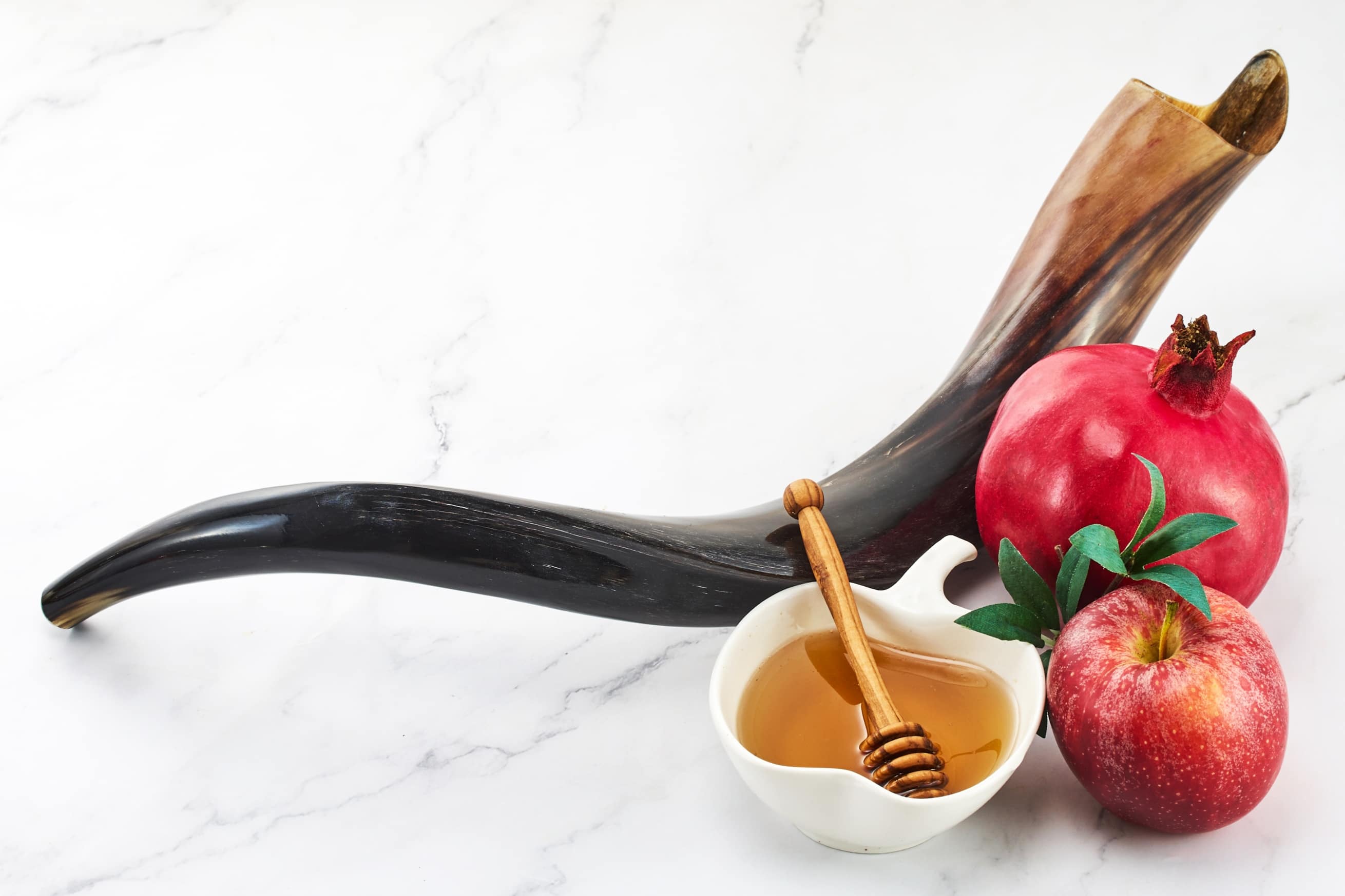 Shofar placed beside apples and honey for Rosh Hashanah