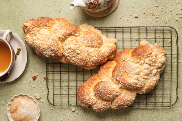 Two braided challah loaves placed side by side on a Shabbat table