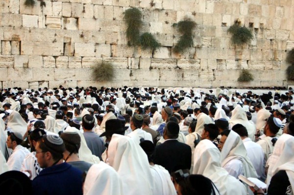 Open High Holiday prayer book with tallit prepared for Yom Kippur